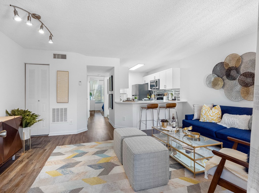 A modern living room with a blue couch and a glass coffee table.